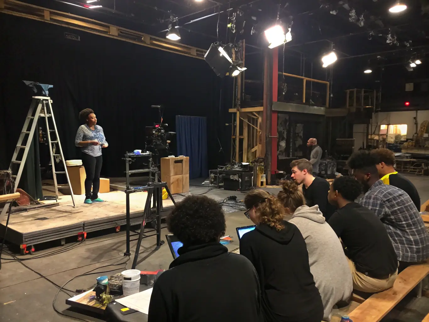 An image of a community workshop where participants are learning about stage lighting and sound techniques, highlighting VERY GOOD VIBES' commitment to education.